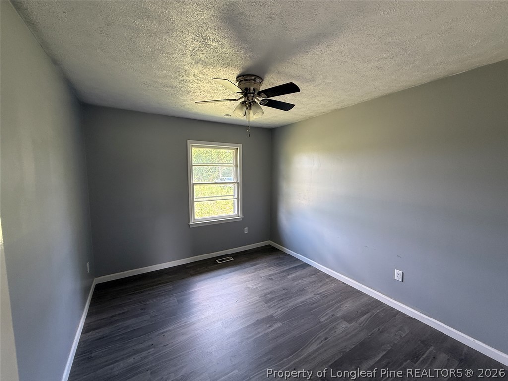 736 Tobermory Road Fayetteville, NC 28306 - Photo 10 of 17 an empty room with wooden floor chandelier fan and windows