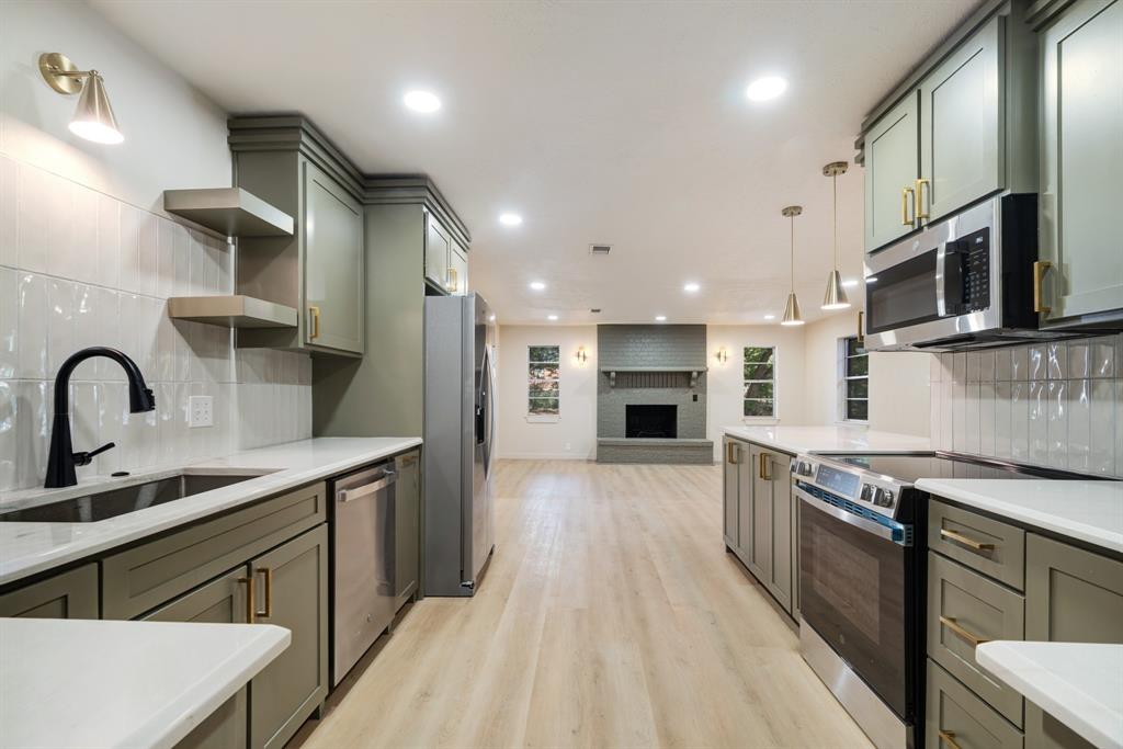 1195 33rd Street Southeast Paris, TX 75460 - Photo 34 of 34 a kitchen with stainless steel appliances granite countertop a sink a stove top oven a refrigerator cabinets and wooden floor