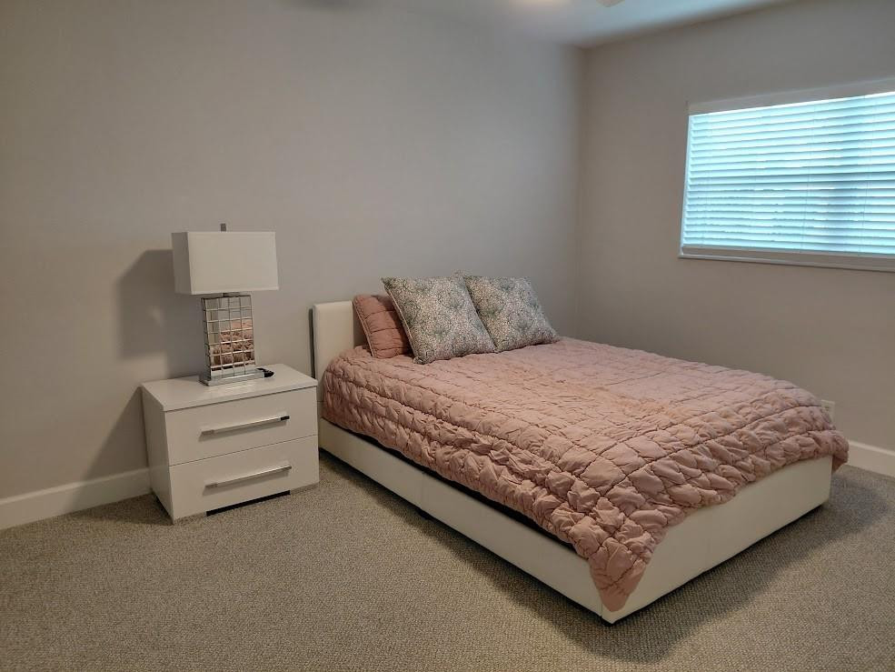 1951 Northeast 39th Street, Unit 127 Lighthouse Point, FL 33064 - Photo 12 of 35 a bed sitting in a bedroom next to a window