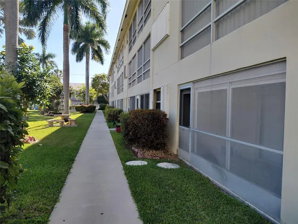 a front view of a house with swimming pool garden and patio