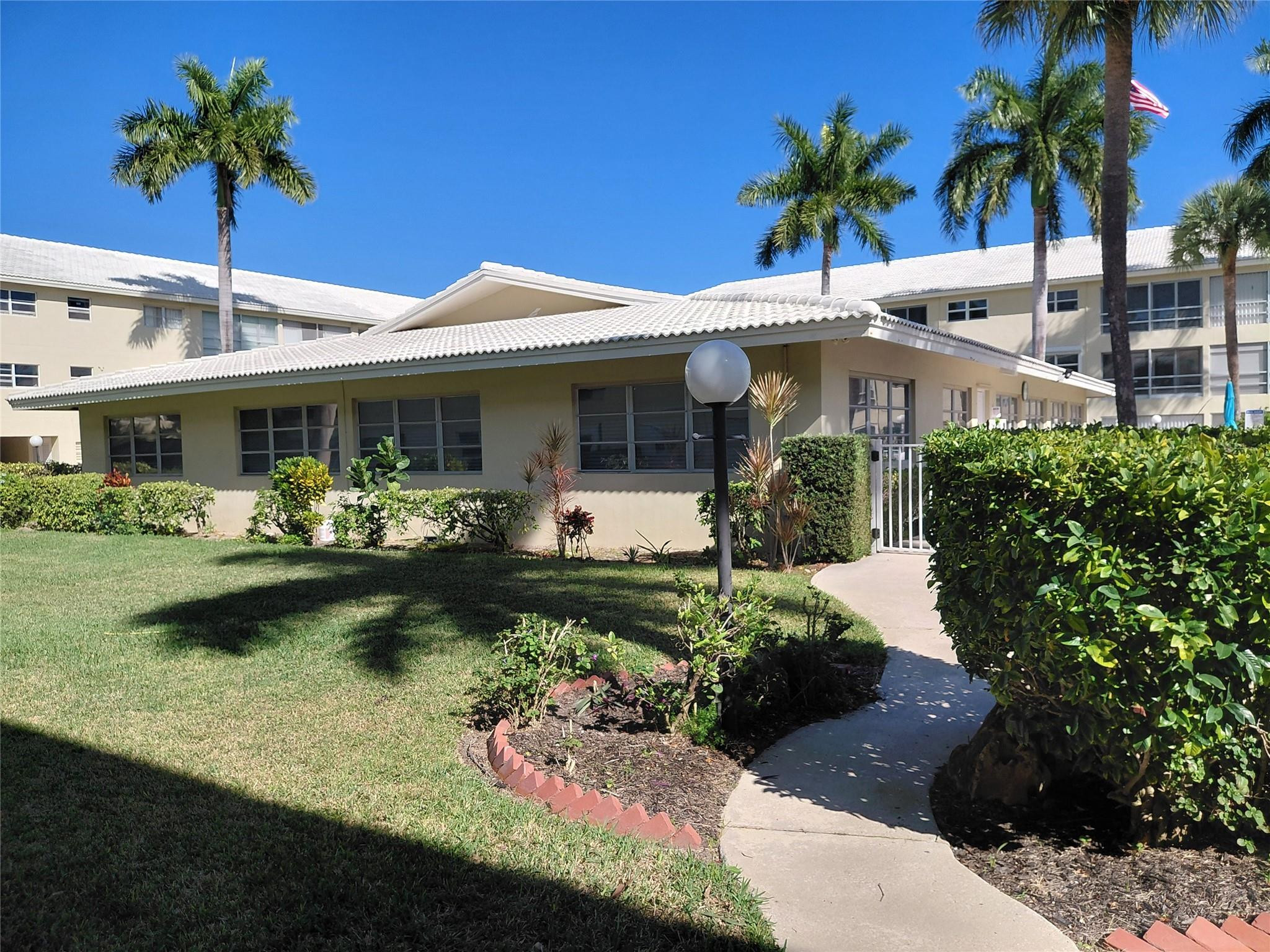 1951 Northeast 39th Street, Unit 127 Lighthouse Point, FL 33064 - Photo 28 of 35 a front view of a house with swimming pool garden and patio