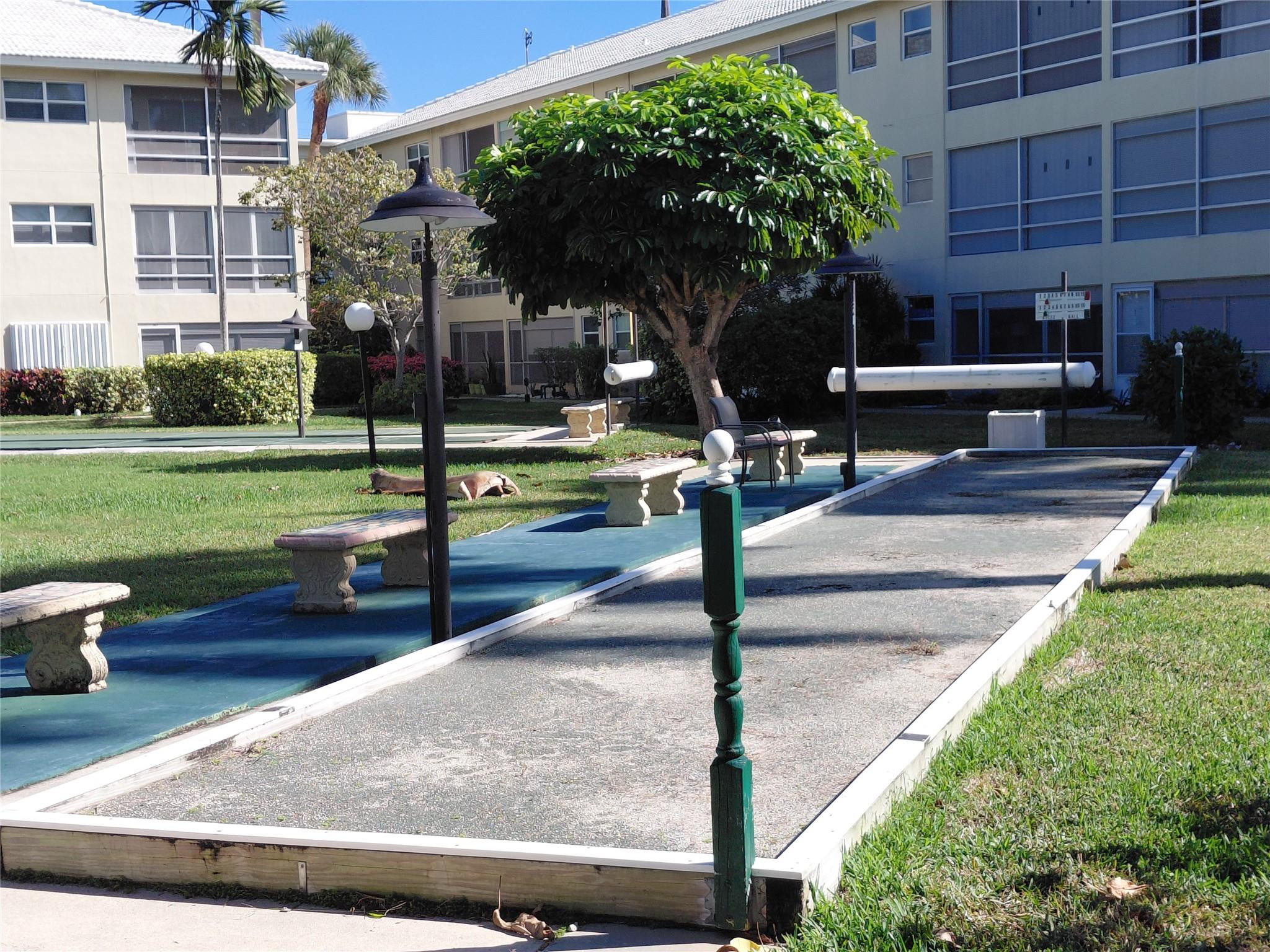 1951 Northeast 39th Street, Unit 127 Lighthouse Point, FL 33064 - Photo 31 of 35 a view of a patio with table and chairs potted plants and large tree
