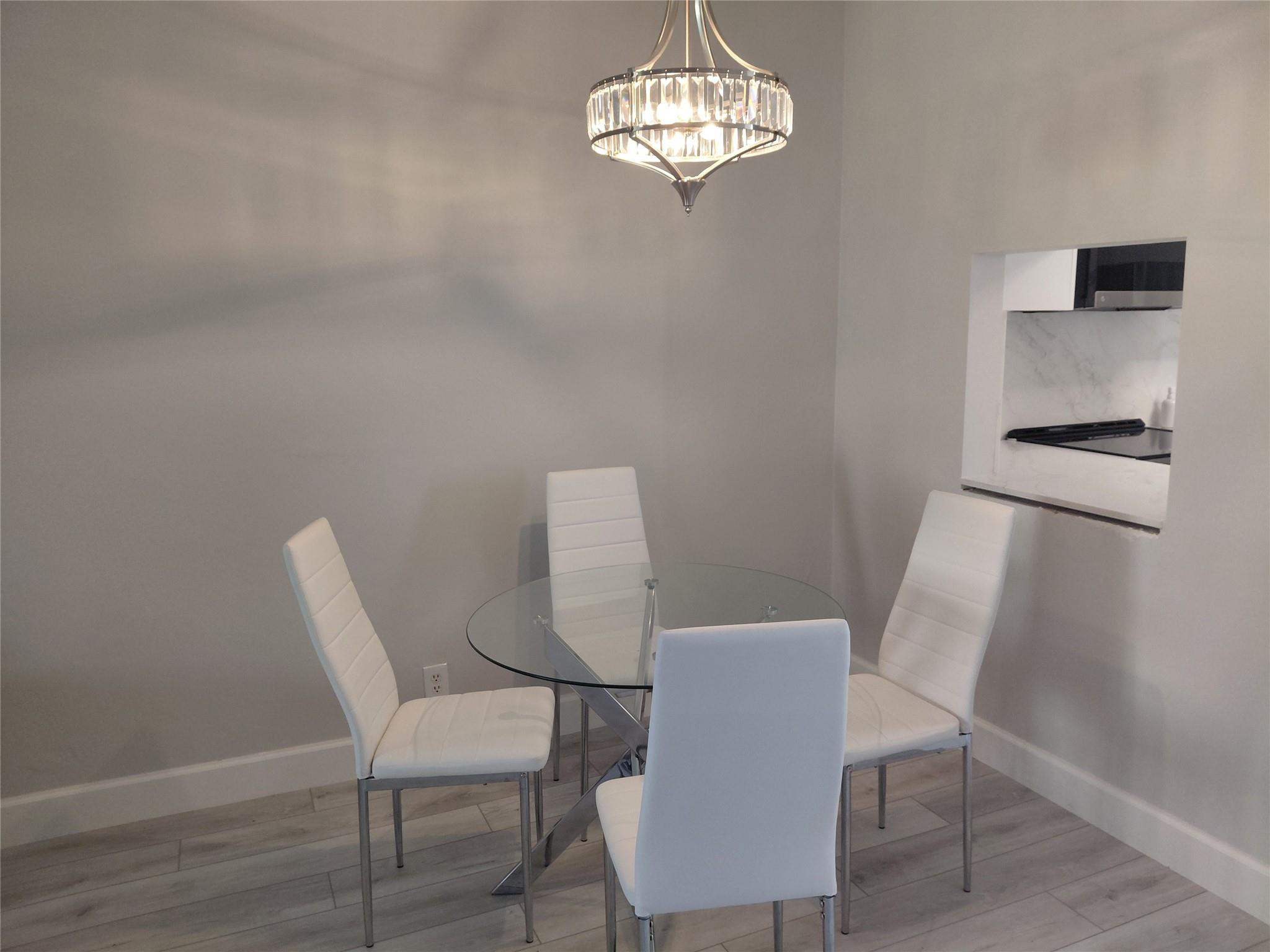 1951 Northeast 39th Street, Unit 127 Lighthouse Point, FL 33064 - Photo 7 of 35 a view of a dining room with furniture and chandelier