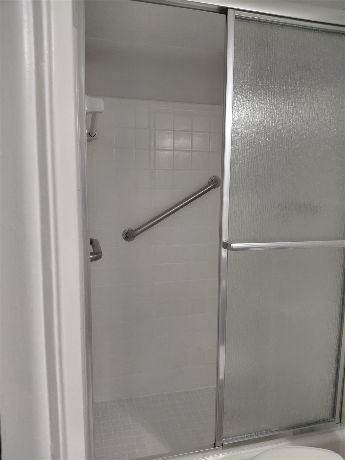 1951 Northeast 39th Street, Unit 127 Lighthouse Point, FL 33064 - Photo 10 of 35 a bathroom with a glass shower door