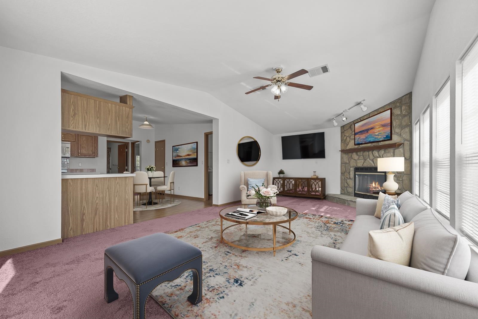 305 Palmetto Bluff Road Palatka, FL 32177 - Photo 11 of 34 Carpeted living area with a stone fireplace, lofted ceiling, rail lighting, and a ceiling fan. Virtually staged.