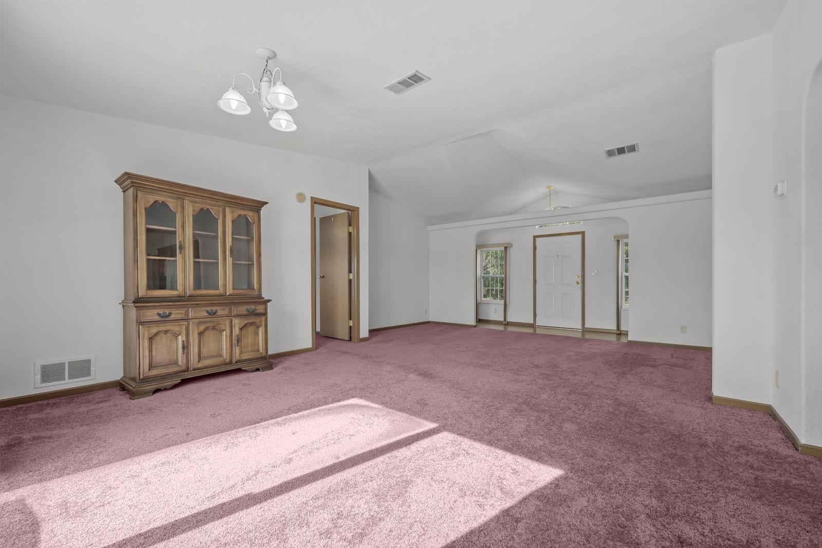 305 Palmetto Bluff Road Palatka, FL 32177 - Photo 4 of 34 Unfurnished living room featuring, carpet, arched walkways, and lofted ceiling