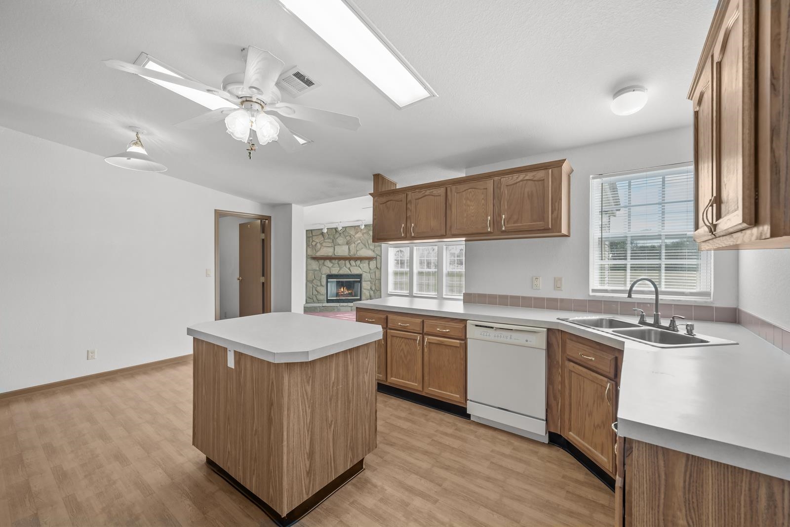 305 Palmetto Bluff Road Palatka, FL 32177 - Photo 6 of 34 Kitchen with light countertops, a center island, white dishwasher, and brown cabinets