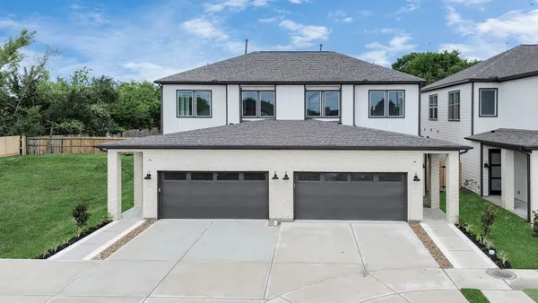 a front view of a house with yard and parking