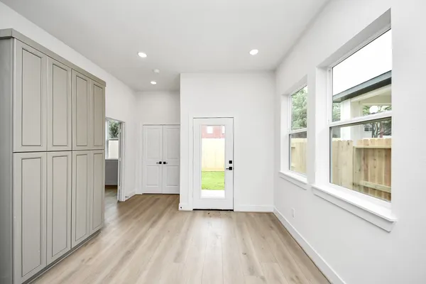 a view of an empty room with wooden floor and a window