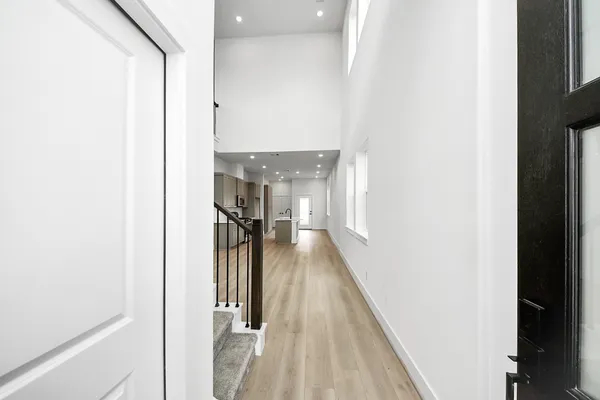 a view of a hallway with a white walls and a window