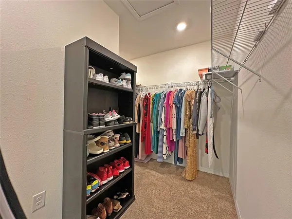 a view of walk in closet with clothes and shoes