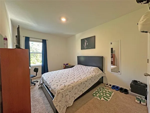 a bedroom with a bed and a dresser next to a window