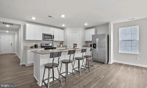 a view of kitchen with refrigerator microwave and wooden floor
