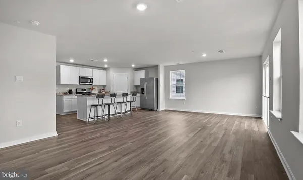 a view of an empty room with wooden floor and windows