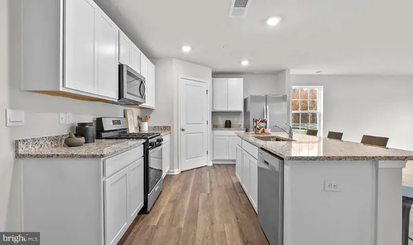 a kitchen with stainless steel appliances granite countertop a stove a sink dishwasher and a refrigerator