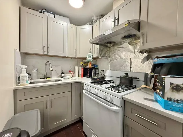 a kitchen with stainless steel appliances granite countertop a sink a stove and cabinets