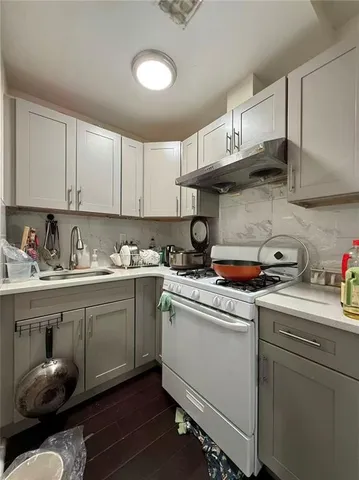 a kitchen with a sink a stove and cabinets