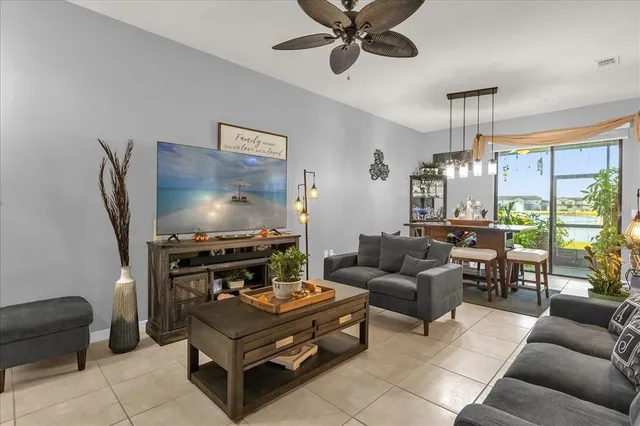 a living room with furniture a flat screen tv and a large window
