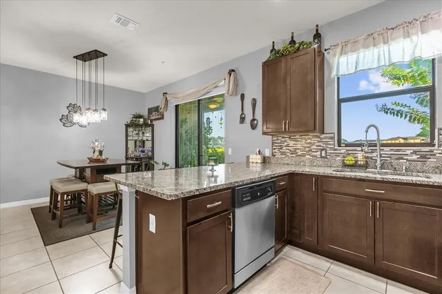 a kitchen with a sink a counter space appliances and cabinets