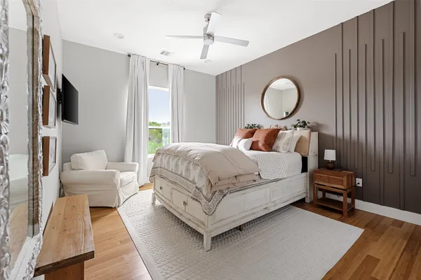 a bedroom with a bed wooden floor and window
