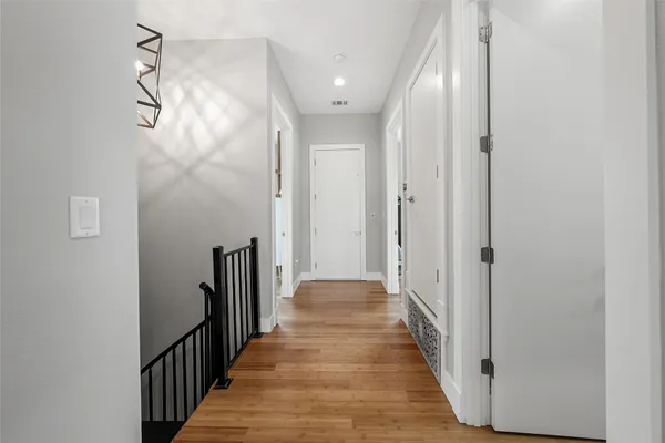 a view of a hallway with wooden floor and staircase