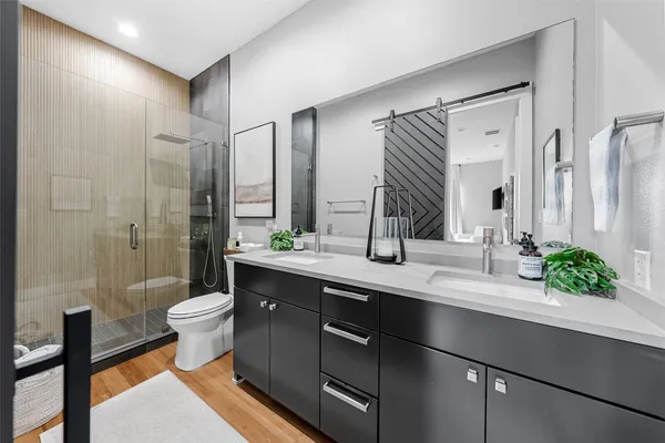 a bathroom with a double vanity sink toilet and shower