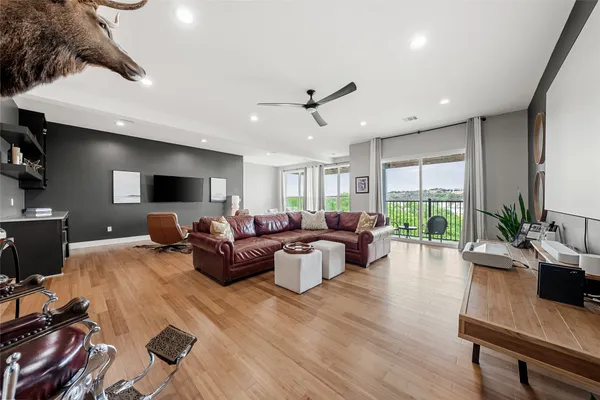 a living room with furniture a large window and wooden floor