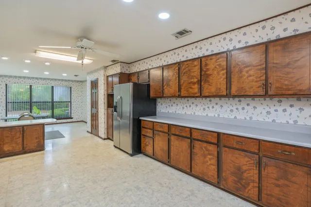 a large kitchen with stainless steel appliances granite countertop a sink and cabinets