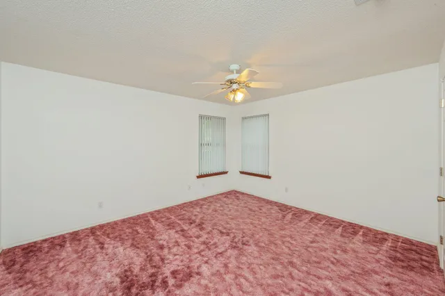 a view of a big room with a chandelier fan and a ceiling fan