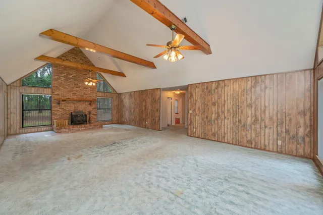 a view of a room with a ceiling fan and window