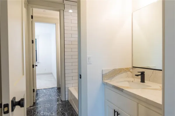 a bathroom with a granite countertop sink and a mirror