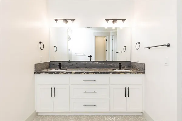 a bathroom with a granite countertop sink and a mirror