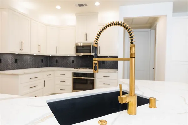 a kitchen with stainless steel appliances kitchen island granite countertop a sink and cabinets