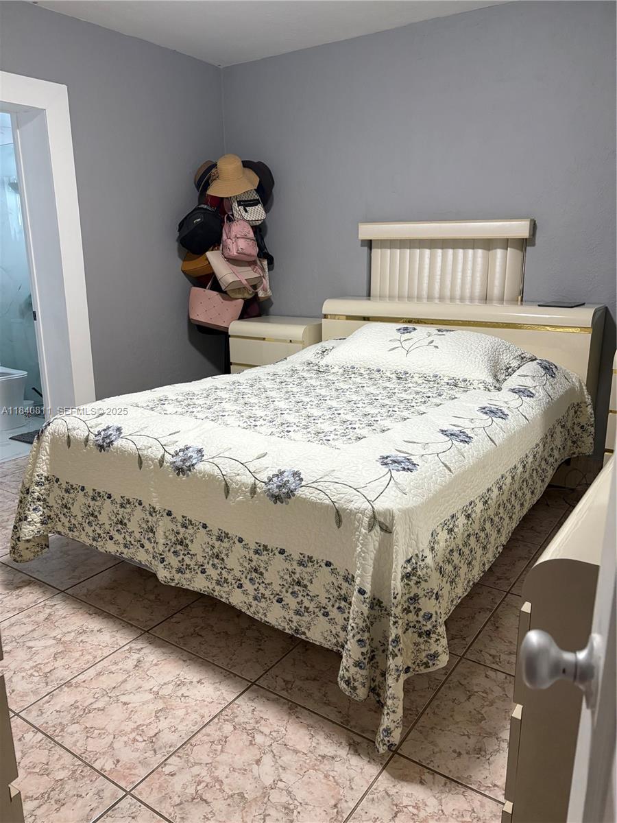 821 East 13th Street Hialeah, FL 33010 - Photo 15 of 25 a bed sitting in a bedroom next to a window