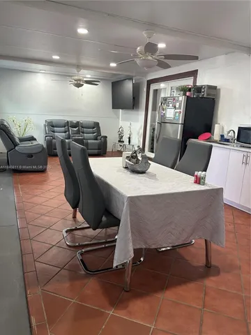 a kitchen with a refrigerator a microwave and a dining table