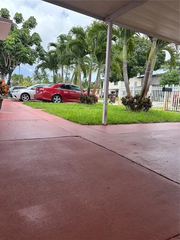 a view of a park with large trees and sign board