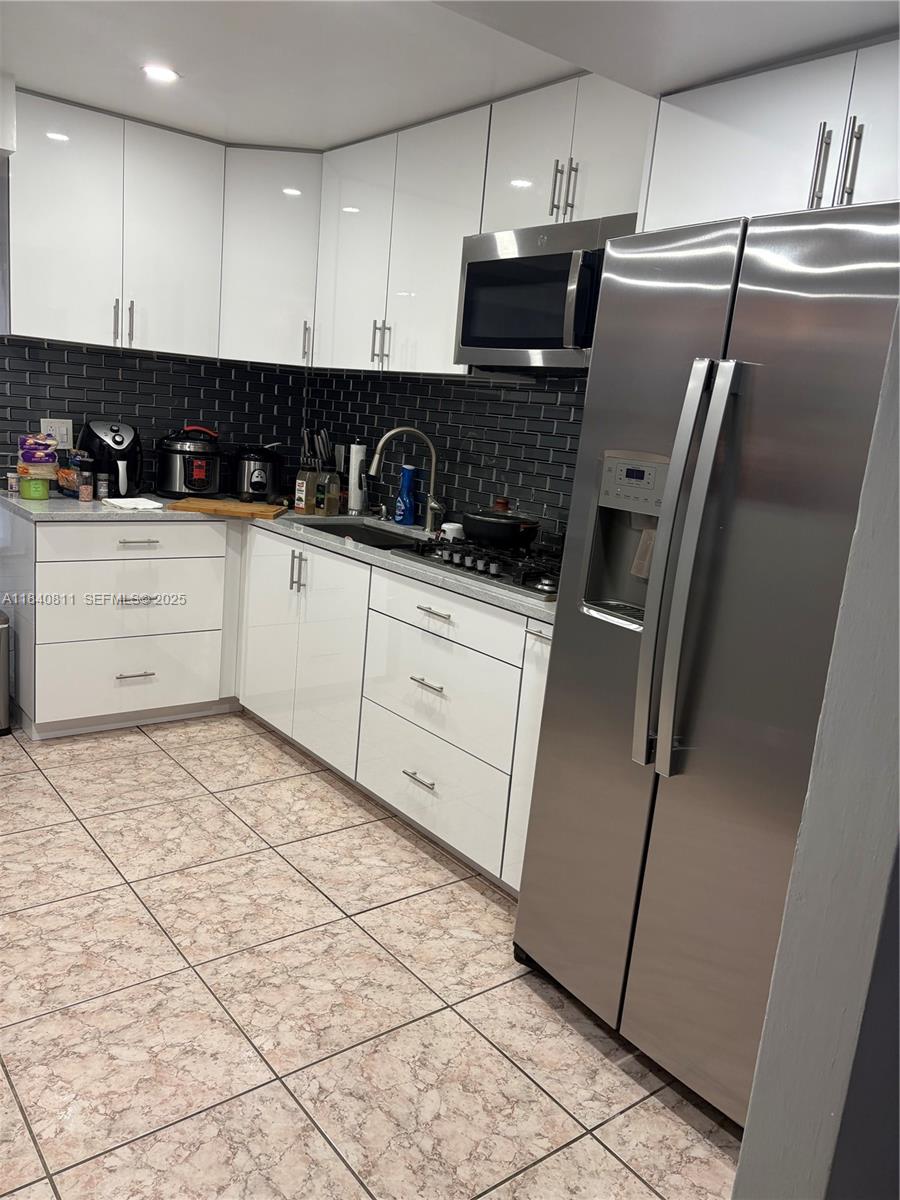 821 East 13th Street Hialeah, FL 33010 - Photo 10 of 25 a kitchen with stainless steel appliances a refrigerator sink and microwave