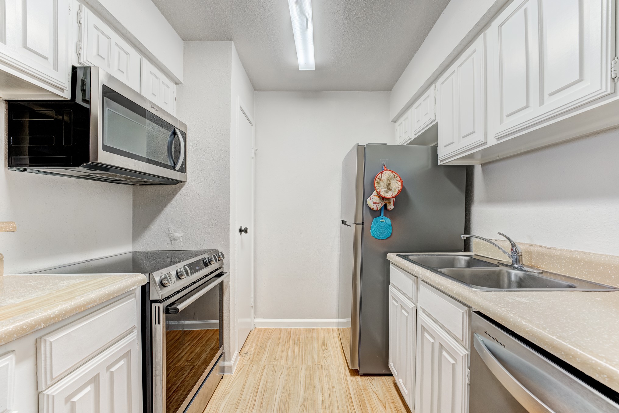 6001 Reims Road, Unit 301 Houston, TX 77036 - Photo 15 of 29 a kitchen with stainless steel appliances granite countertop a sink and a stove top oven
