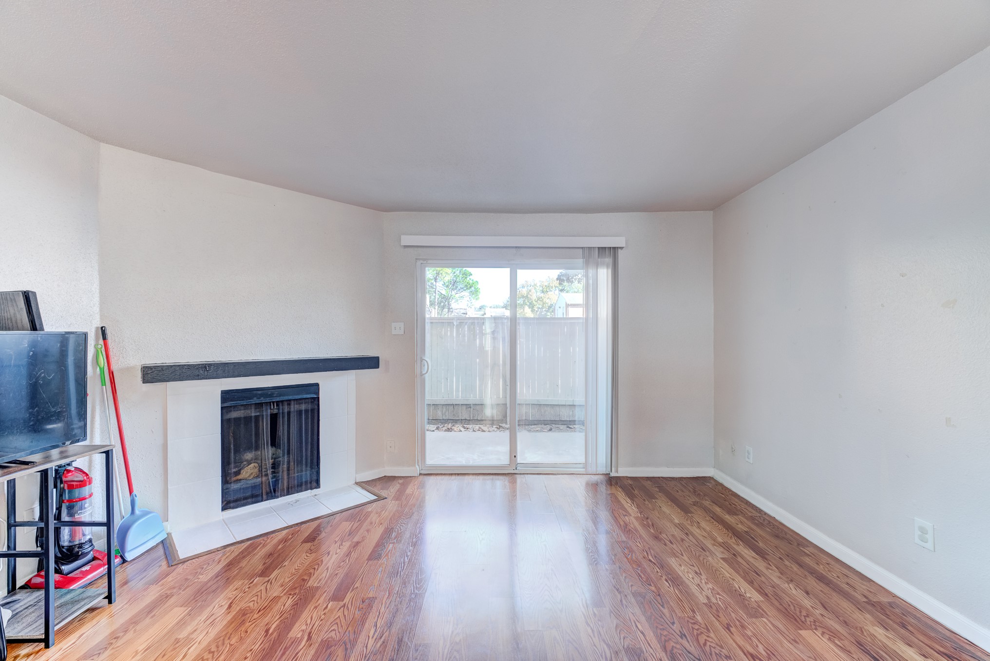 6001 Reims Road, Unit 301 Houston, TX 77036 - Photo 9 of 29 an empty room with wooden floor fireplace and windows