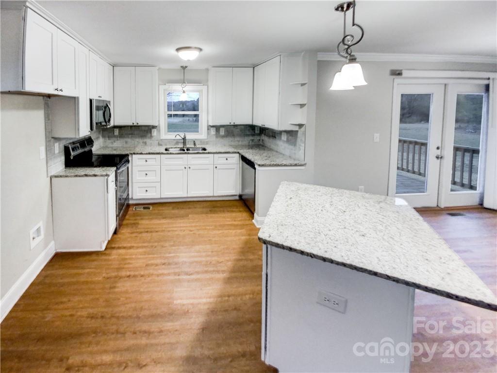 3020 Potter Road Waxhaw, NC 28173 - Photo 3 of 17 a kitchen with granite countertop a sink a counter space appliances and cabinets