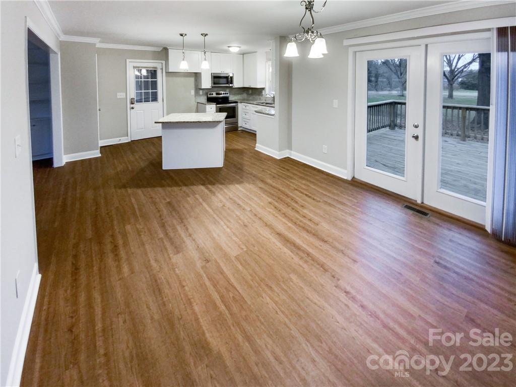 3020 Potter Road Waxhaw, NC 28173 - Photo 5 of 17 a kitchen with stainless steel appliances kitchen island wooden floors and granite counter tops