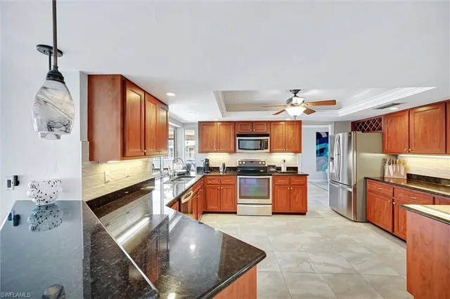 a large kitchen with stainless steel appliances granite countertop a sink and cabinets