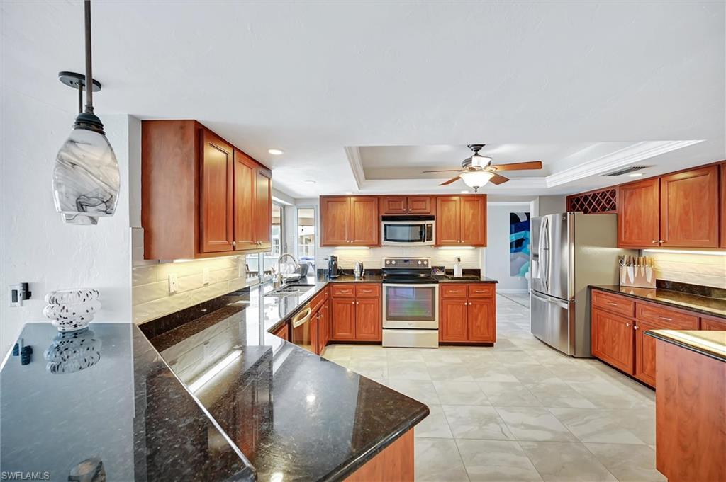 69 Ocean Drive Punta Gorda, FL 33950 - Photo 13 of 44 a large kitchen with stainless steel appliances granite countertop a sink and cabinets