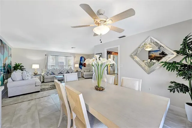 a living room with furniture kitchen view and a chandelier