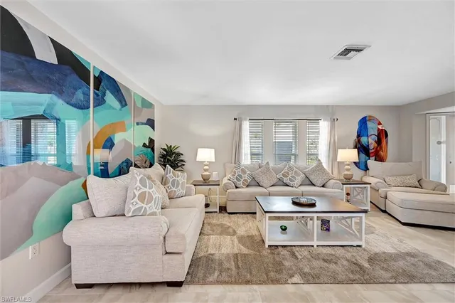 a living room with furniture and a painting on the wall