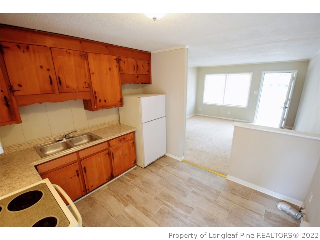 1308 King Street, Unit A Spring Lake, NC 28390 - Photo 5 of 11 a kitchen with stainless steel appliances granite countertop a stove a sink and a refrigerator