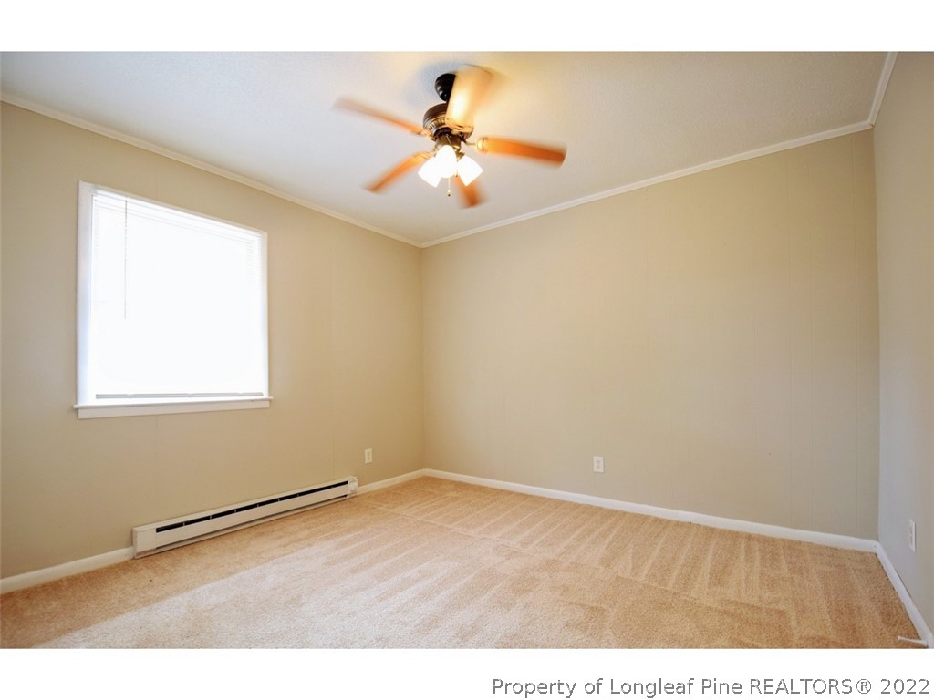1308 King Street, Unit A Spring Lake, NC 28390 - Photo 9 of 11 a view of an empty room with wooden floor and a chandelier fan