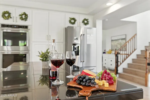 a room with lots of white furniture and potted plants