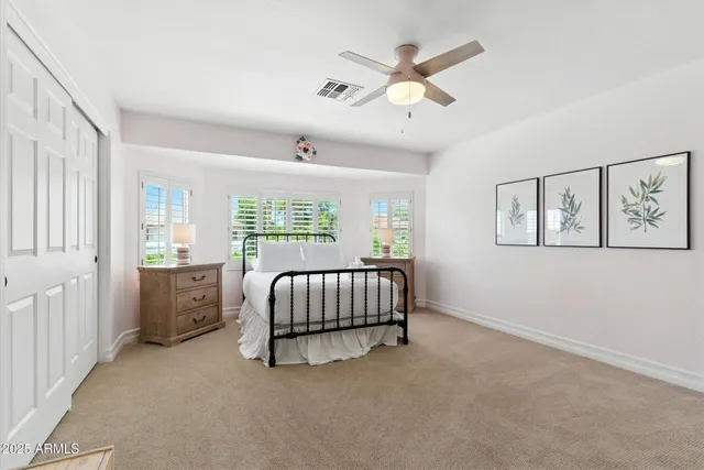 a spacious bedroom with a bed and a chandelier