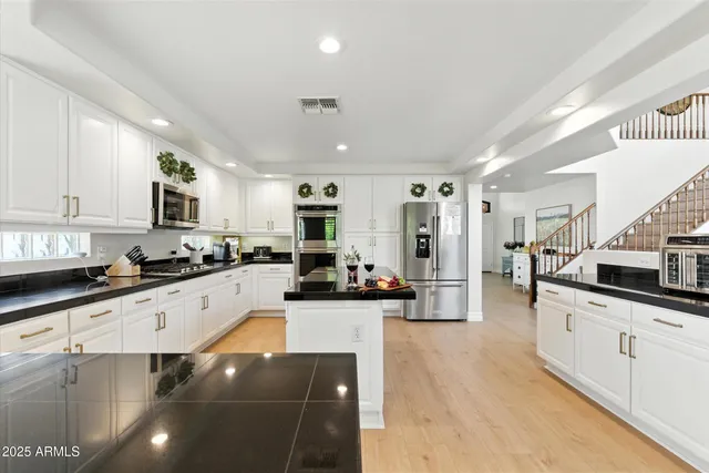 a large kitchen with stainless steel appliances lots of counter space and wooden floor